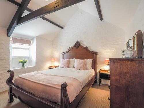 um quarto com uma cama grande e uma cabeceira em madeira em Maes y Derw Coach House Newcastle Emlyn em Newcastle Emlyn