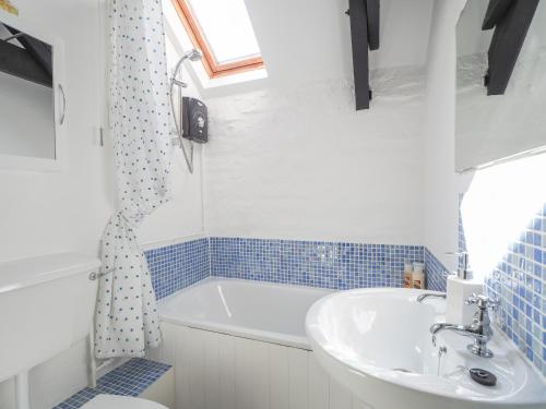 uma casa de banho com uma banheira branca e um lavatório. em Maes y Derw Coach House Newcastle Emlyn em Newcastle Emlyn