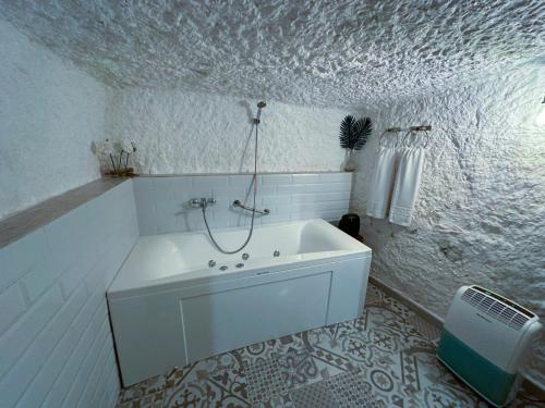 y baño blanco con bañera y ducha. en Casa del Juez, Alojamiento rural singular, en Alcalá del Júcar