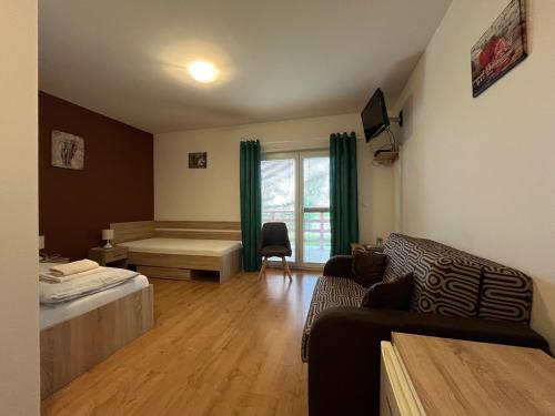 a living room with a bed and a couch at Penzión a Reštaurácia Harmónia Ostratice in Malé Ostratice