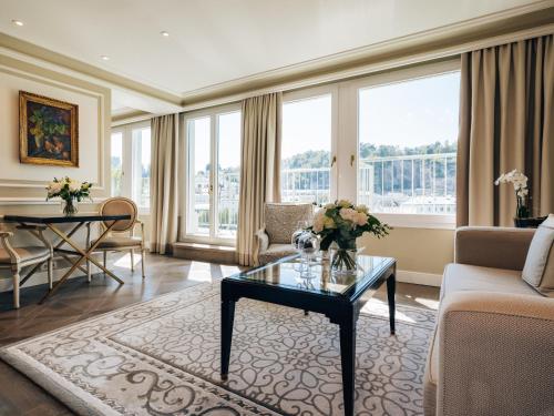 a living room with a couch and a table with flowers on it at Hotel Sacher Salzburg in Salzburg