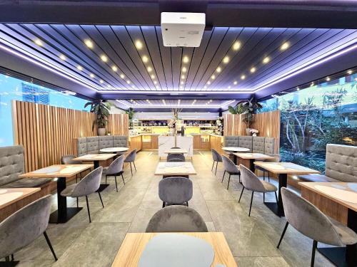 a restaurant with tables and chairs and lights at Canova Hotel in Milan