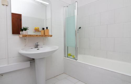 un bagno bianco con lavandino e doccia di Old Town Apartment Panoramic NearThe Beach ad Albufeira