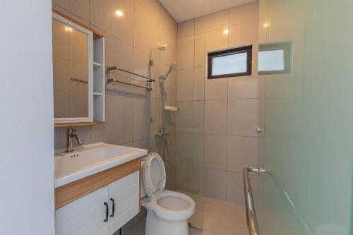 a bathroom with a toilet and a sink at Casa Yumi in Denpasar