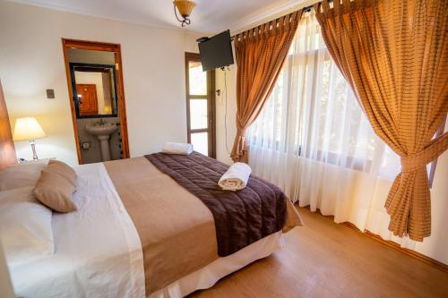 a bedroom with a large bed and a large window at Hotel Naturaleza Vertientes de Elqui in El Molle