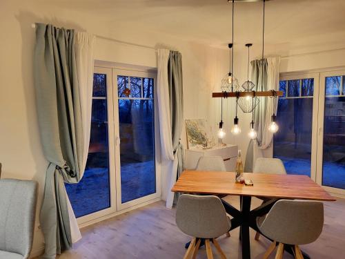 a dining room with a table and chairs and windows at Friesenperle in Tönning