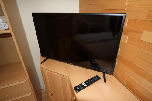 a television on a wall with a remote control at Privatzimmer Fam. Führer in Ottenschlag