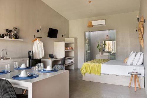 ein Schlafzimmer mit einem Bett und einem Tisch mit Stühlen in der Unterkunft Vila Flor Studios in Praia de Moitas