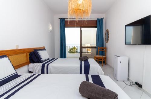 um quarto de hotel com duas camas e uma televisão em Old Town Apartment NearThe Beach em Albufeira