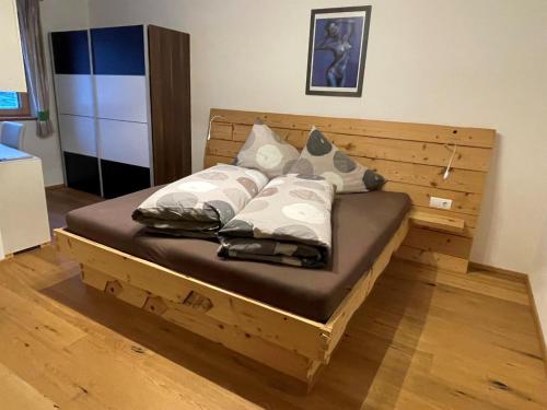 - un lit en bois avec des oreillers dans l'établissement Ferienwohnung BodnLois, à Matrei in Osttirol