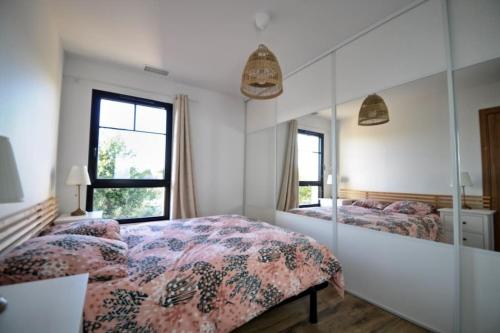 um quarto com 2 camas e um espelho em Maison Arcachonnaise neuve et grande terrasse em La Teste-de-Buch