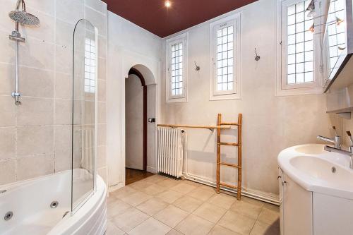 a bathroom with a tub and a sink and a shower at Hôtel Particulier - Palais des Congrès in Neuilly-sur-Seine