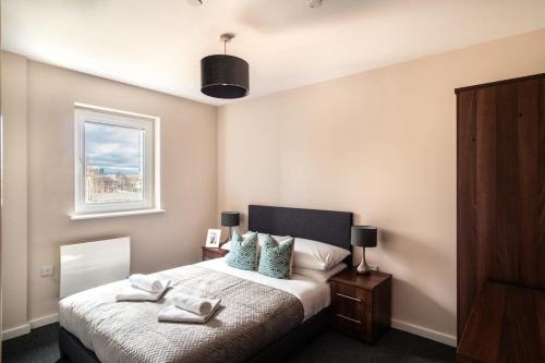 a bedroom with a bed with two towels on it at Modern & Stylish 2 Bed Apartment in Manchester in Manchester