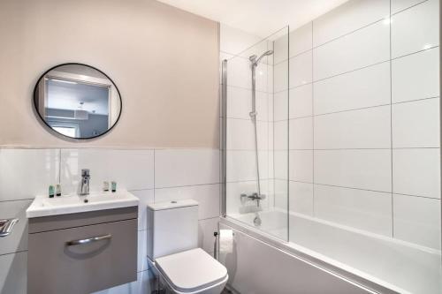 a bathroom with a toilet and a sink and a mirror at Modern & Stylish 2 Bed Apartment in Manchester in Manchester