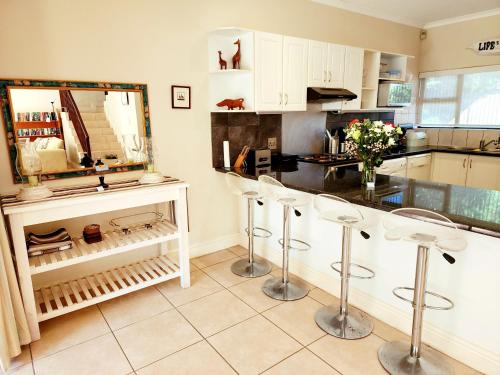a kitchen with two bar stools and a counter at Villa T7 - Selborne Golf Estate in Pennington
