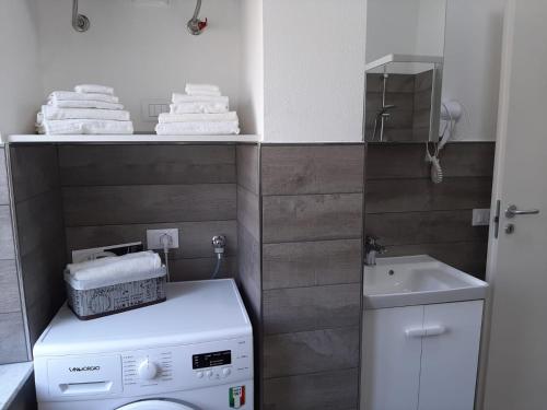 a small bathroom with a washing machine and a sink at Casa Fuerte in Laigueglia