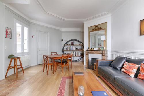 un salon avec un canapé et une table dans l'établissement Résidor - Haussmanian flat in the heart of Paris, à Paris