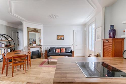 a living room with a table and a couch at Résidor - Haussmanian flat in the heart of Paris in Paris