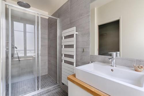 a white bathroom with a sink and a shower at Résidor - Haussmanian flat in the heart of Paris in Paris