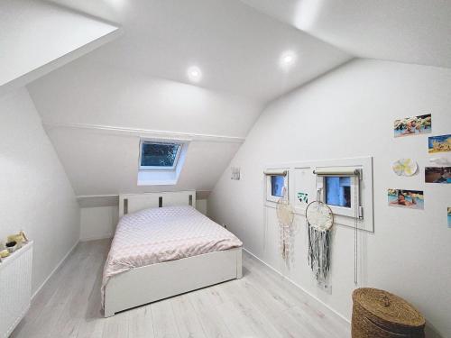 a small bedroom with a bed in a attic at Maison Helena in Yerres