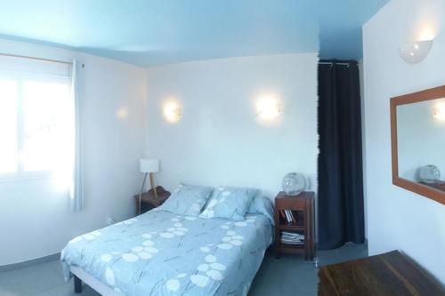 Schlafzimmer mit einem Bett und einem Spiegel in der Unterkunft maison de rêve dans un écrin de verdure au calme in Eccica-Suarella