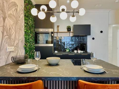 une cuisine avec une table avec des assiettes et des verres à vin dans l'établissement Floréa Reims avec du charme proche gare et centre, à Reims