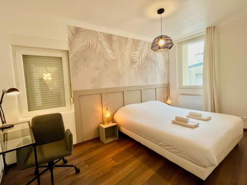 a bedroom with a bed and a desk and a chair at Floréa Reims avec du charme proche gare et centre in Reims