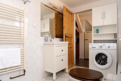 a bathroom with a washing machine and a washer at Rosewood - Apartment by Comfort Housing in Falkensee