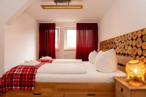 a bedroom with a large bed with red curtains at Rosewood - Apartment by Comfort Housing in Falkensee