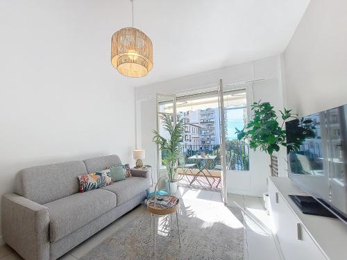un salon avec un canapé et une grande fenêtre dans l'établissement Nestor&Jeeves - STUDIO RIVIERA - Central - Very close sea, à Nice