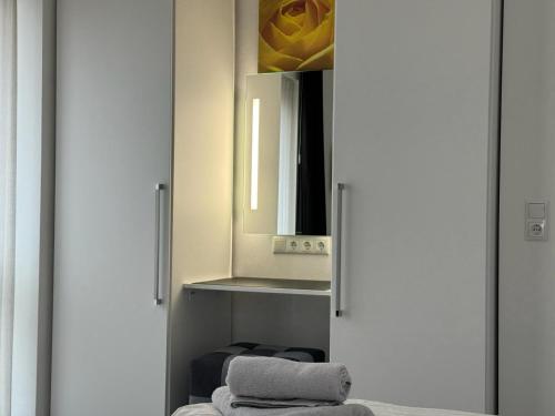 ein Bad mit einem Schrank mit einem Spiegel und Handtüchern in der Unterkunft Strandloft-Frieshörn Nordsee Park Dangast in Dangast