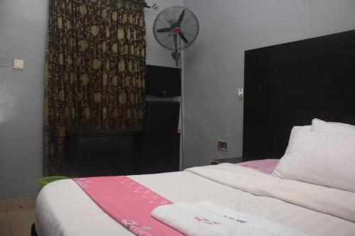 a bedroom with a bed with a fireplace and a fan at D’ ISLAND AND CLUB HOTEL in Lekki