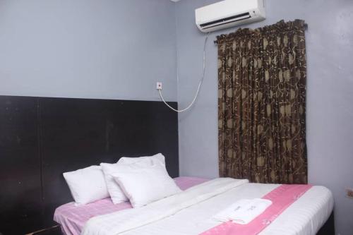 um quarto com uma cama com uma cabeceira preta e almofadas brancas em D’ ISLAND AND CLUB HOTEL em Lekki