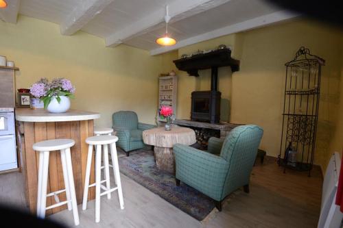 a living room with a table and chairs and a fireplace at Les hébergements insolites de Quénécan in Perret