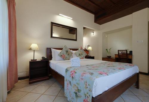 a bedroom with a bed and two lamps and a mirror at Mystic Mayapott, Thekkady in Thekkady