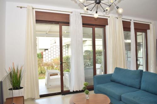 ein Wohnzimmer mit einem blauen Sofa und einer Glasschiebetür in der Unterkunft Lalzit Bay Dream Villa - Happy Rentals in Lalzit Bay