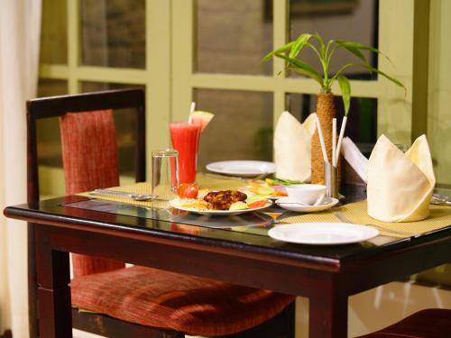 a table with a plate of food on it at Mystic Mayapott, Thekkady in Thekkady