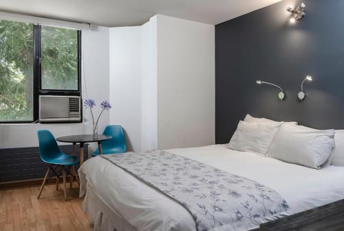 a bedroom with a bed and a table and chairs at Hotel Nippon y Centro de Eventos in Santiago