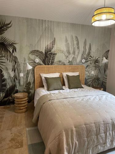 - une chambre avec un grand lit et du papier peint tropical dans l'établissement Les gites at Domaine les Caizergues, à Brissac