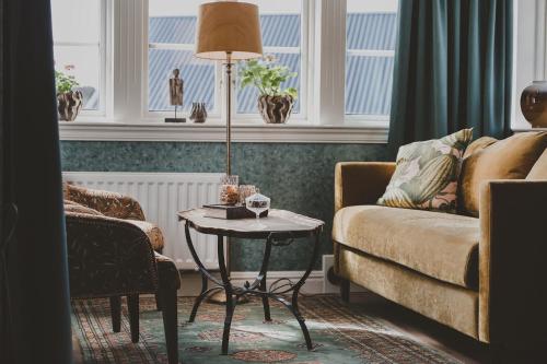uma sala de estar com um sofá e uma mesa em Kläpphagen Koster em Sydkoster