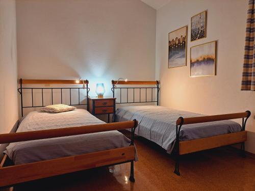a bedroom with two beds and a lamp on a table at casa Jone in Tomar