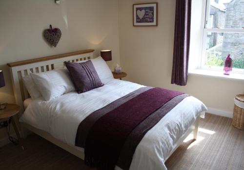 a bedroom with a bed with a purple and white blanket at Dinmore in Richmond