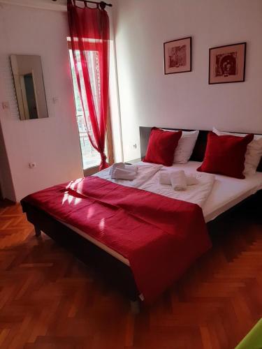 a bedroom with a large bed with red pillows at Apartments Vila Miranda 2 in Barbat na Rabu