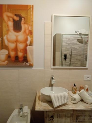 a bathroom with a sink and a picture of a man at LA MOIA in Cerete