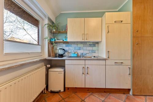 a kitchen with white cabinets and a sink and a window at Bücherträume in Windeby