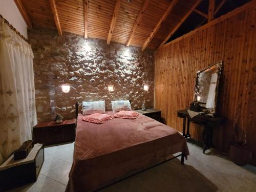 a bedroom with a bed and a stone wall at Grandpa's home in Areopolis