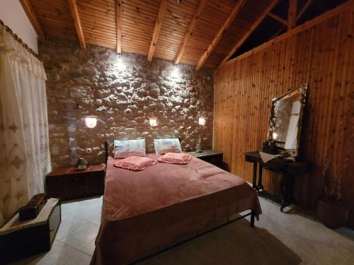 um quarto com uma cama e uma parede de pedra em Grandpa's home em Areopoli
