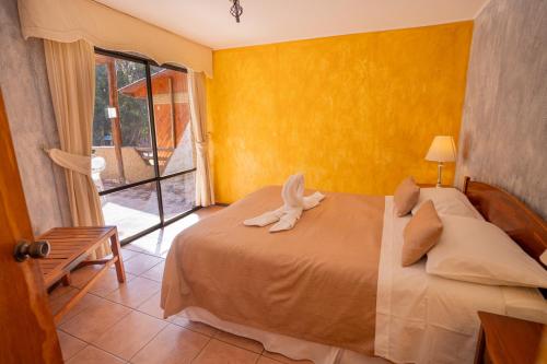 a bedroom with a bed with a stuffed rabbit on it at Hotel Naturaleza Vertientes de Elqui in El Molle
