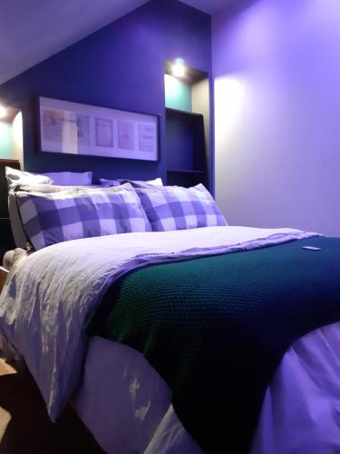 sypialnia z łóżkiem z niebieską ścianą w obiekcie Factory, appart hotel Valenciennes w mieście Aulnoy