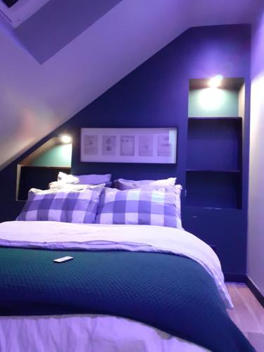 a bedroom with a bed with a blue wall at Factory, appart hotel Valenciennes in Aulnoy
